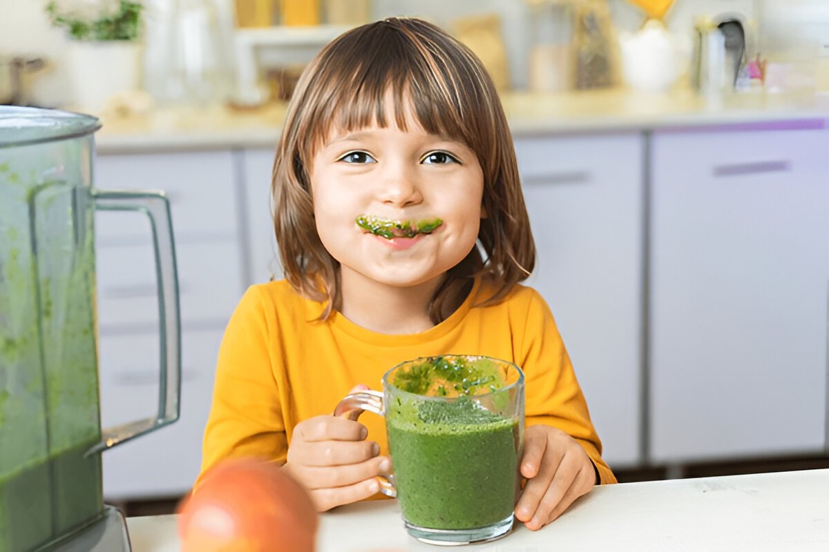 kid drinking healthy smoothie made from fruits and vegetables